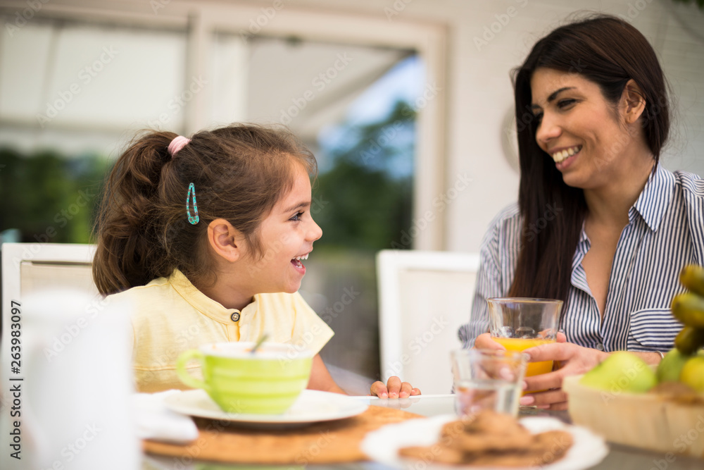 Happy mother and daughter having breakfast at home Happy mother and daughter having breakfast at home