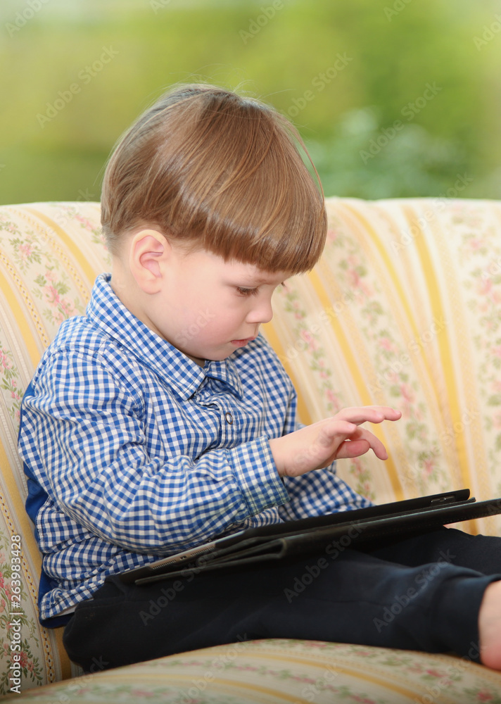 Ein kleiner Junge bedient ein ipad Ein kleiner Junge bedient ein ipad