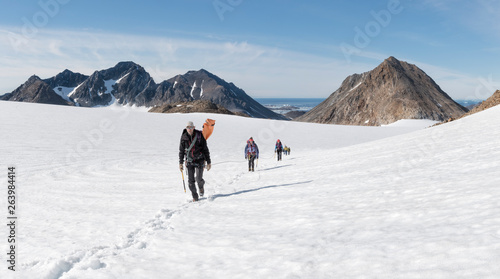 Greenland, Sermersooq, Kulusuk, Schweizerland Alps, group of people walking in snow photo