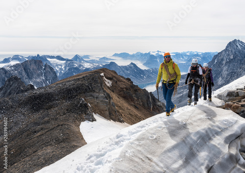 Greenland, Sermersooq, Kulusuk, Schweizerland Alps, mountaineers walking in snowy mountainscape photo