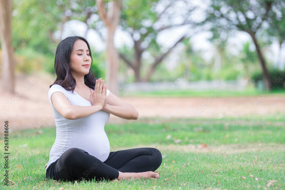 Portrait of asian Beautiful pregnant woman at the park,Thailand people,Happy woman concept,Her play yoga on the lawn Portrait of asian Beautiful pregnant woman at the park,Thailand people,Happy woman concept,Her play yoga on the lawn