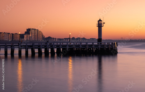 Long exposure image of the Nieuwpoort pier and lighthouse at sunset