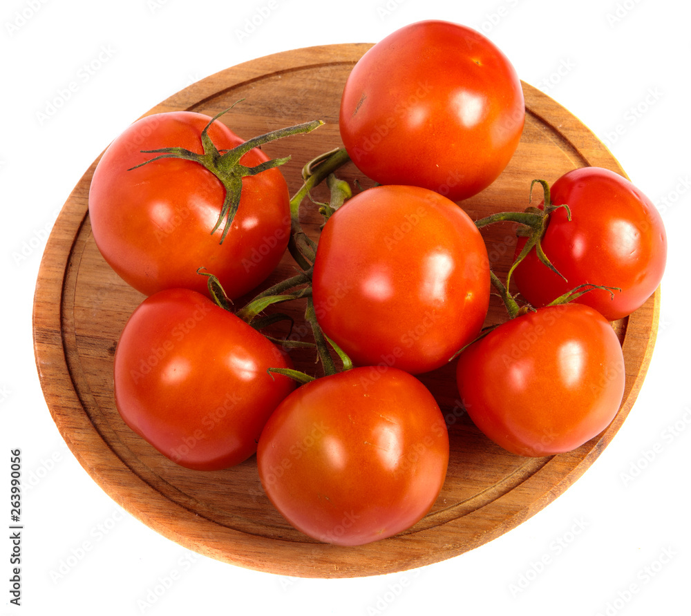 ripe red tomatoes on a round wooden cutting board. white background ripe red tomatoes on a round wooden cutting board. white background