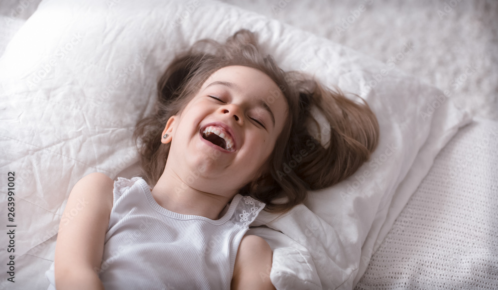 Fototapeta premium Little cute girl smiling in bed , sleep concept