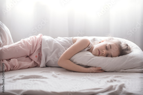 Cute little girl sleeps sweetly in bed