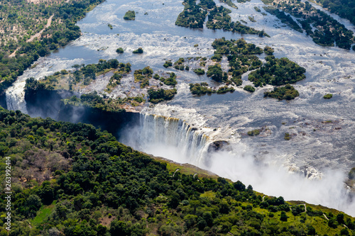 Victoria Falls from aerial view. Waterfall in southern Africa on the Zambezi River at the border between Zambia and Zimbabwe. Rainbow on the river. 