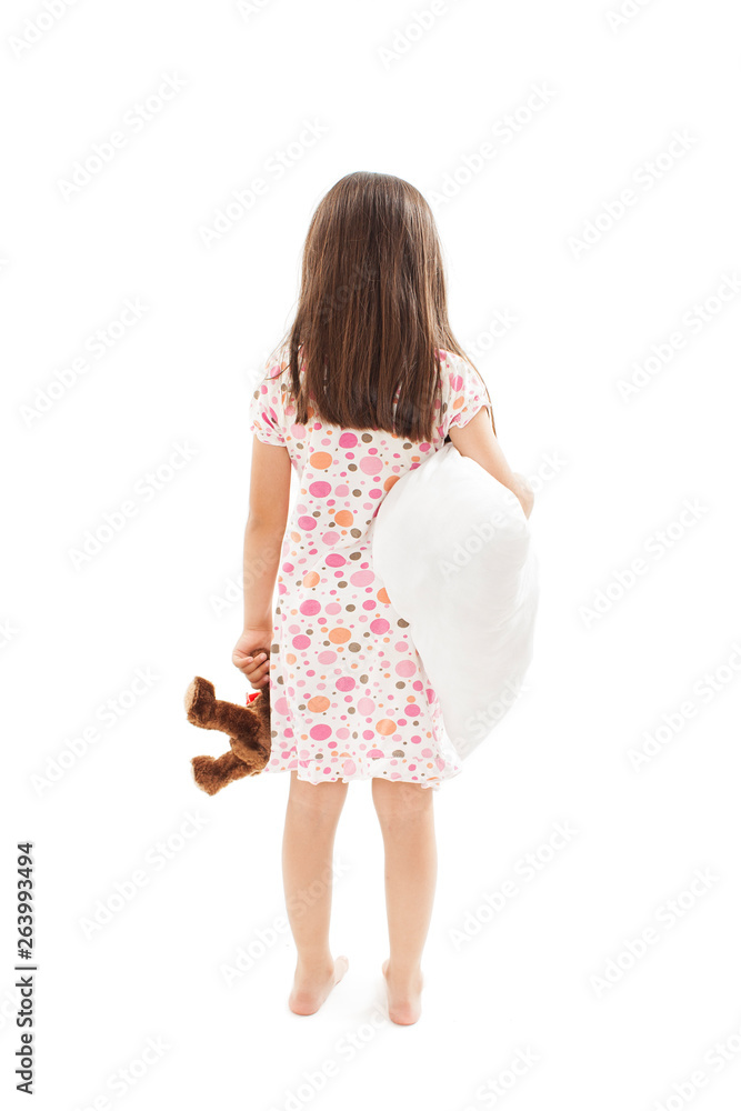 Back view of little girl with pillow and soft teddy in hand, intends to go to bed. Rear view. Isolated on white background. Back view of little girl with pillow and soft teddy in hand, intends to go to bed. Rear view. Isolated on white background.