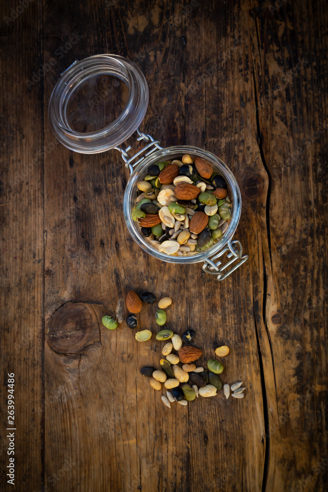 Preserving jar of roasted soy beans, seeds and nuts on wood Preserving jar of roasted soy beans, seeds and nuts on wood