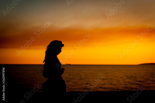 silhouette of woman at the beach at sunset