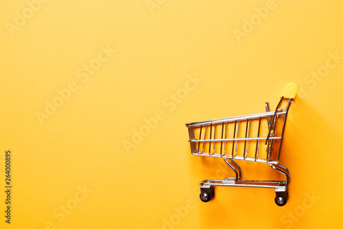 Fotografia, Obraz Shopping concept. shopping cart on a yellow background.