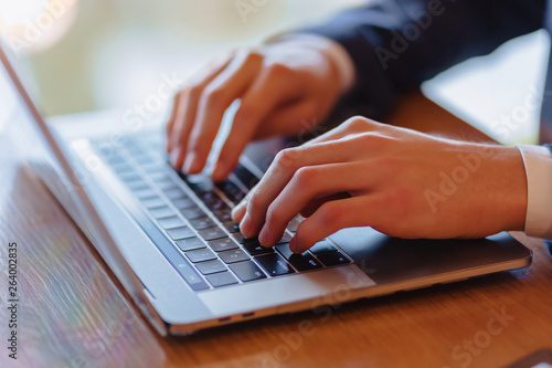 man typing on laptop at cafe hands closeup