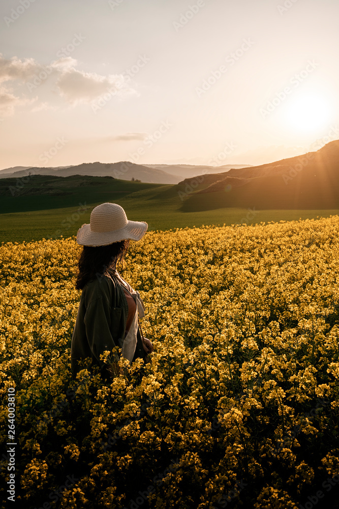 Fototapeta premium Unrecognizable woman walking among flowers
