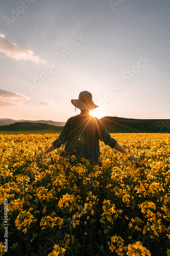 Unrecognizable woman walking among flowers