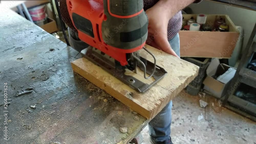 The carpenter is using electric saw The carpenter is using electric saw