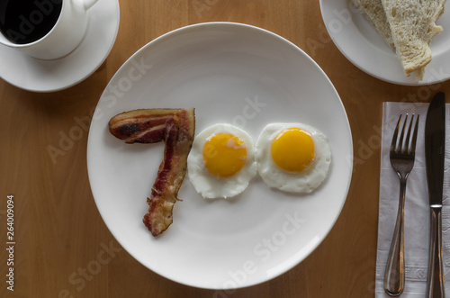 fried egg and bacon on a plate in the shape of the number 700 photo