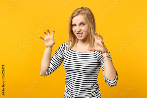 Φωτογραφία Funny young woman in striped clothes shouting, growling like animal, making cat claws gesture isolated on yellow orange wall background