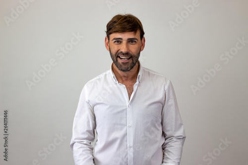 Fashion portrait of handsome young man with brown hair looking cheerful, looking at the camera. Isolated on white background. © Sergio Barceló