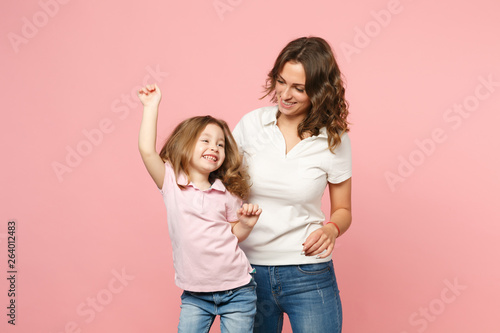 Woman in light clothes have fun with cute child baby girl. Mother, little kid daughter isolated on pastel pink wall background, studio portrait. Mother's Day, love family, parenthood childhood concept