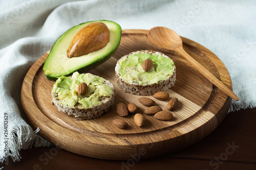 sandwich with avocado and almonds on a wooden brown background 