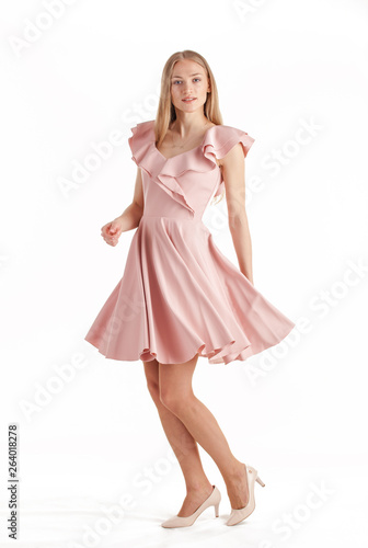 Beautiful young blonde woman in pink dress isolated on white background