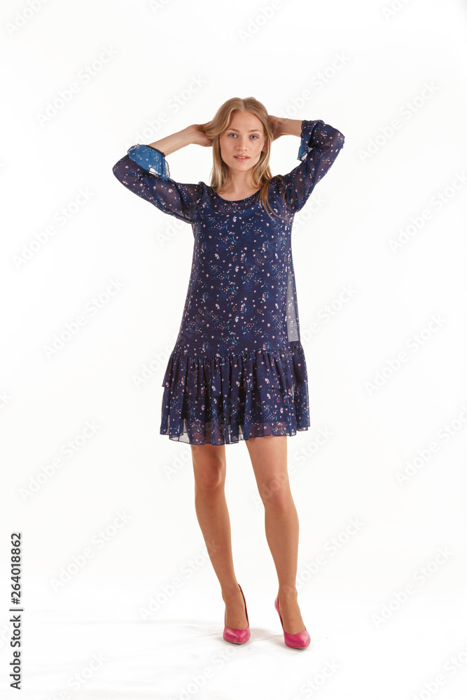 Beautiful young blonde woman in dark blue dress with floral print isolated on white background Beautiful young blonde woman in dark blue dress with floral print isolated on white background