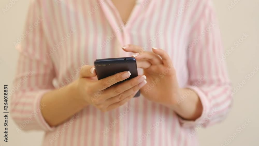 Woman hand typing mobile message on screen smartphone. Close up female hands holding smartphone and browsing website Woman hand typing mobile message on screen smartphone. Close up female hands holding smartphone and browsing website