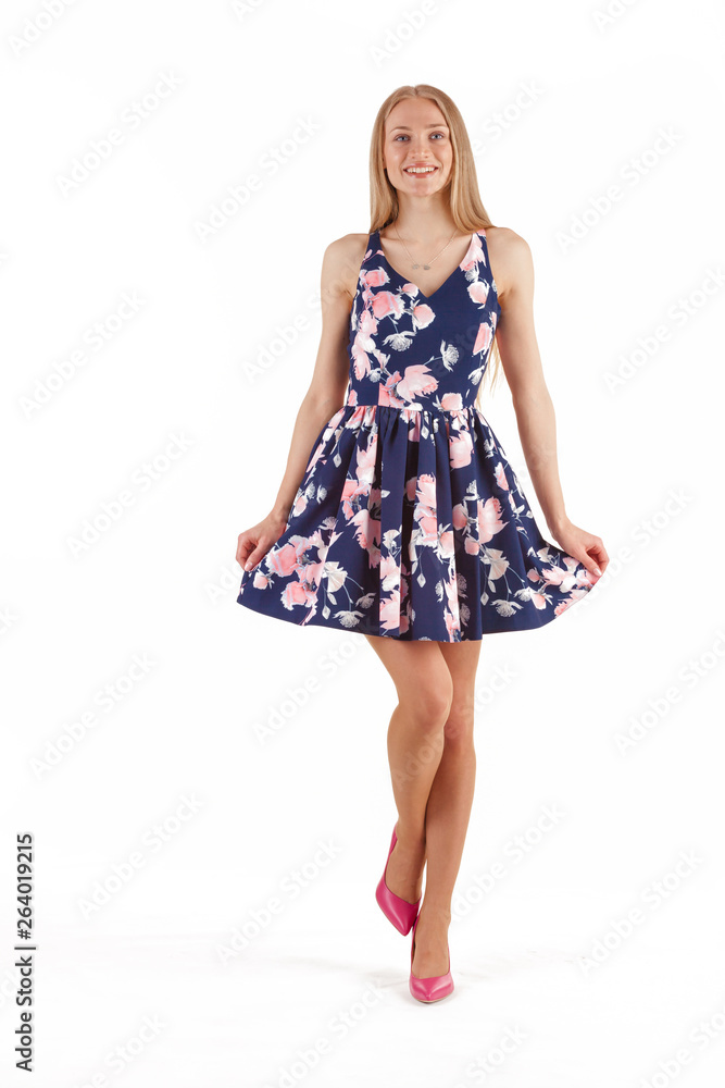 Beautiful young blonde woman in dark blue dress with floral print isolated on white background Beautiful young blonde woman in dark blue dress with floral print isolated on white background