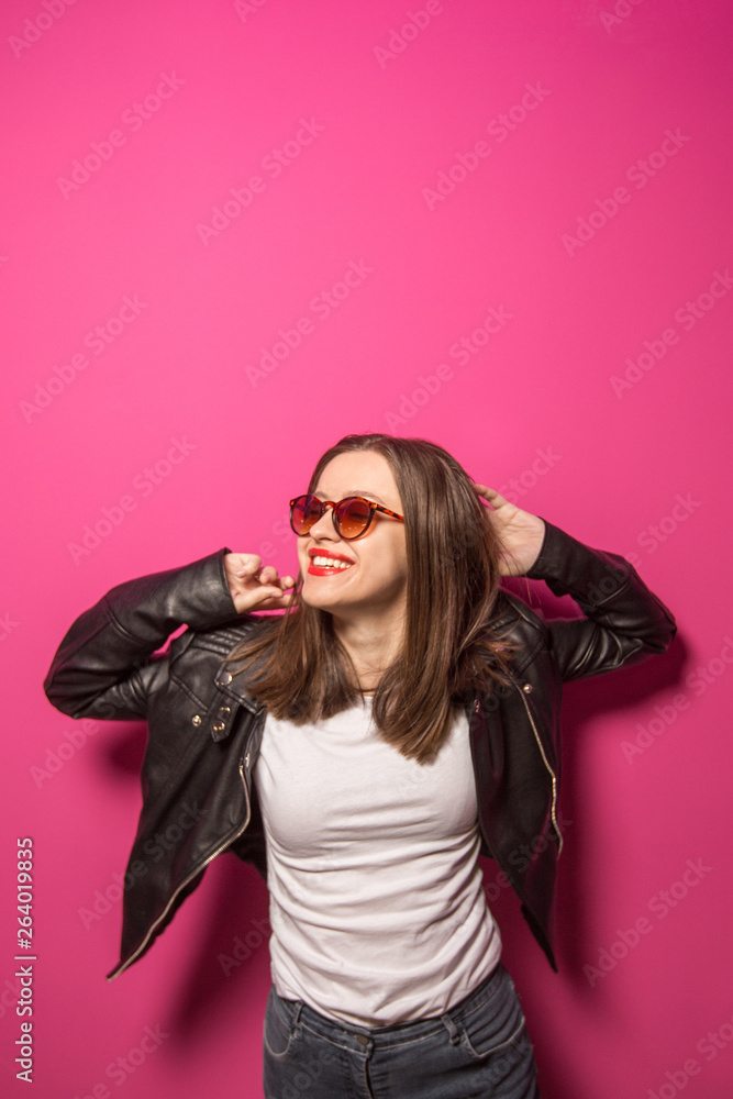 Fashioned girl in leather jacket in dark glasses in pink anf blue neon lights background. Fashioned girl in leather jacket in dark glasses in pink anf blue neon lights background.