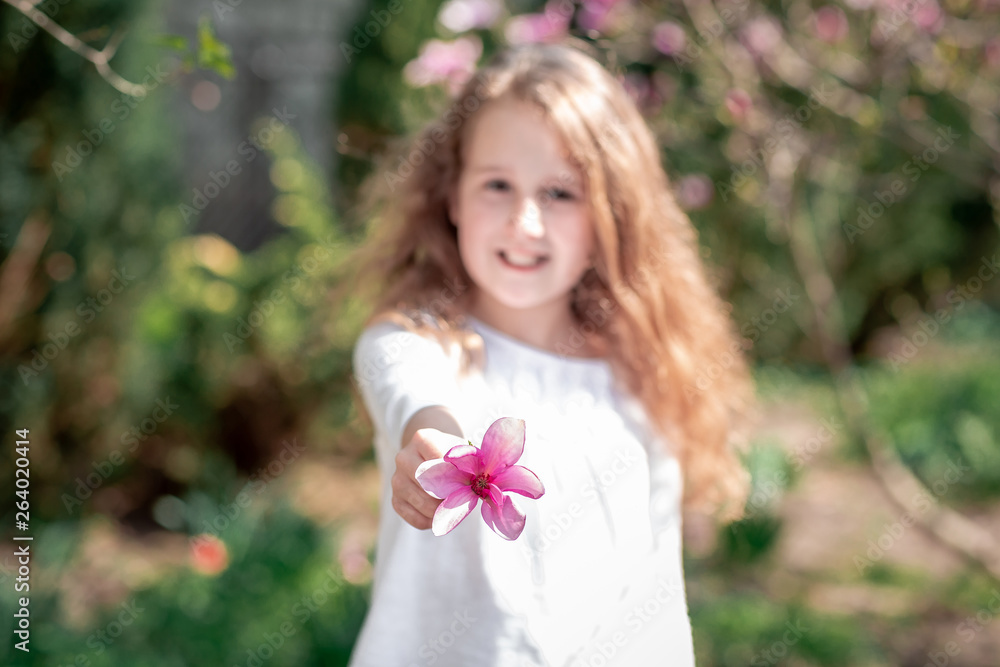 beautiful purple flower close up. magnolia tree in blossom. Adorable girl smile in park with blossoming flowers. selective focus beautiful purple flower close up. magnolia tree in blossom. Adorable girl smile in park with blossoming flowers. selective focus