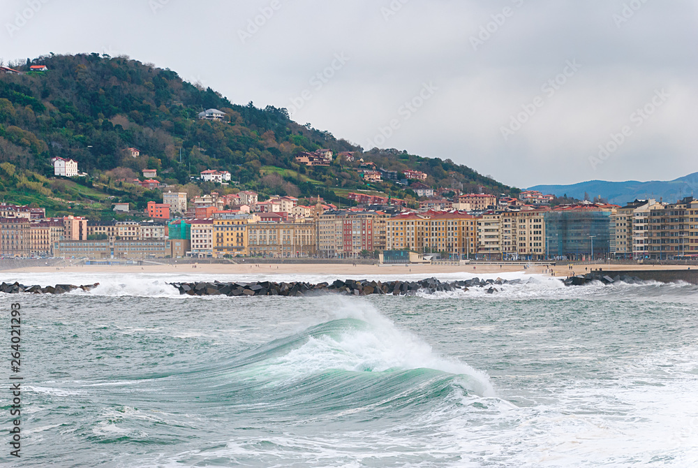 Sea waves with the city of Donostia - San Sebastian at background, Spain