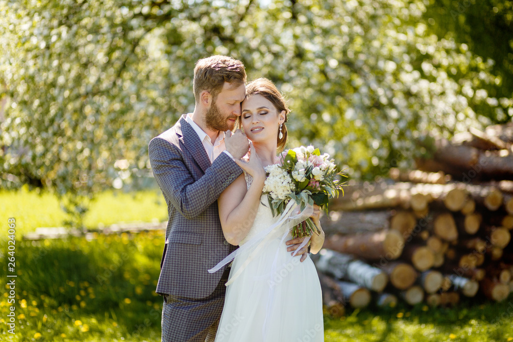 Bride and groom hugging on a sunny day in the park Bride and groom hugging on a sunny day in the park