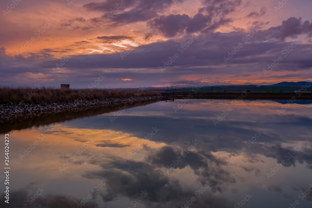 Picturesque landscape with reflections at sunset over the salt-mines in Pomorie, Bulgaria.