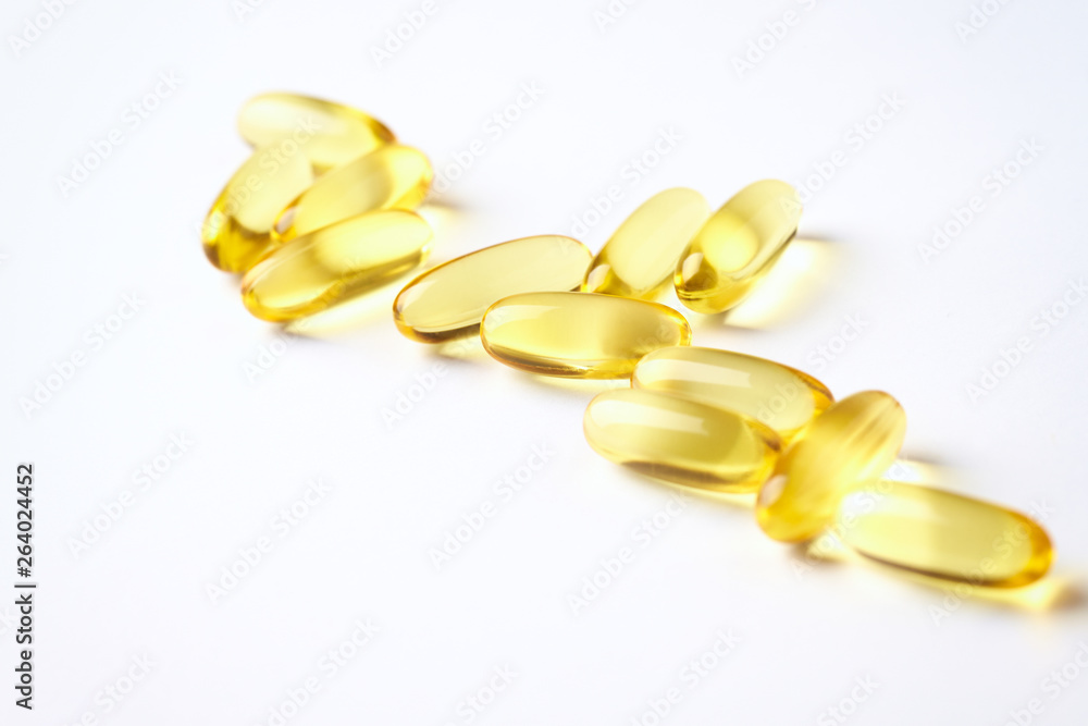 Fish oil capsules with omega 3 on white background. Concept for a healthy dietary supplementation. Immune System Support. Close up. Copy space. Fish oil capsules with omega 3 on white background. Concept for a healthy dietary supplementation. Immune System Support. Close up. Copy space.