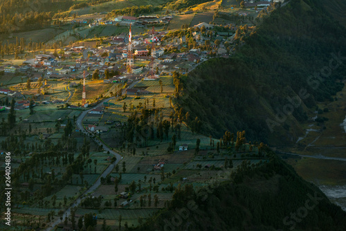 Beautiful aerial view of green village in early morning during sunrise in the mist, Cemoro lawang village, ring of fire, mount Bromo, semeru national park, East Java, Indonesia
