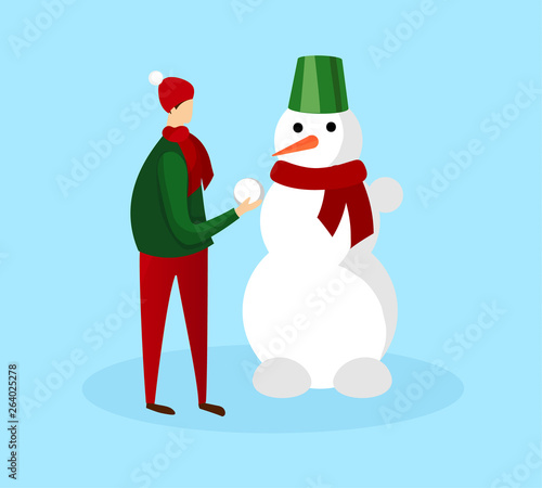 Teenage Boy in Warm Winter Clothing Making Snowman