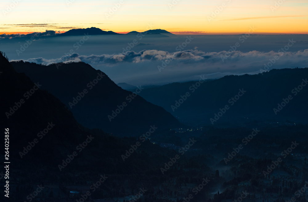 Peaceful atmosphere in early morning during sunrise over the shadow top mountain forest in mist.