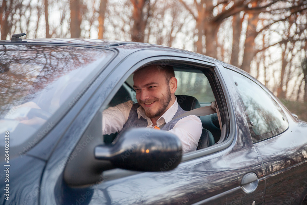 one young man, sitting in drivers seat in car. shoot thought window outdoor. one young man, sitting in drivers seat in car. shoot thought window outdoor.
