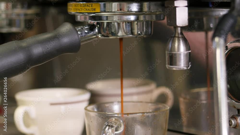 cappuccino pouring into clear cup from side angle. Cappuccino being made in clear mug. cappuccino pouring into clear cup from side angle. Cappuccino being made in clear mug.