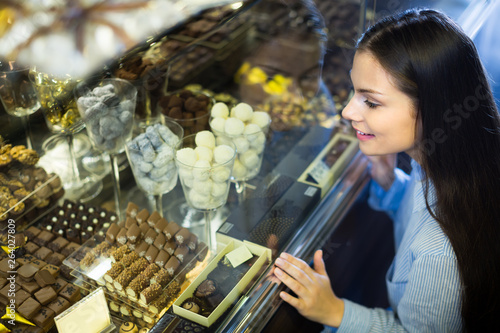 Smiling girl choosing chocolates. photo