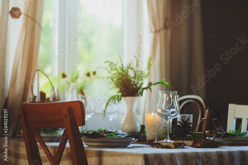 summer country house with festive table decorated for dinner. Cozy place with candles in rustic natural style