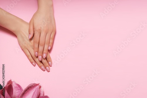 Manicure. Beautiful and delicate hands on pink background with pink flowers. © forma82