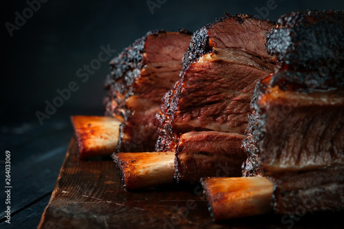 Fotografie, Obraz Baked beef brisket on the ribs smoked with a dark crust on a wooden Board
