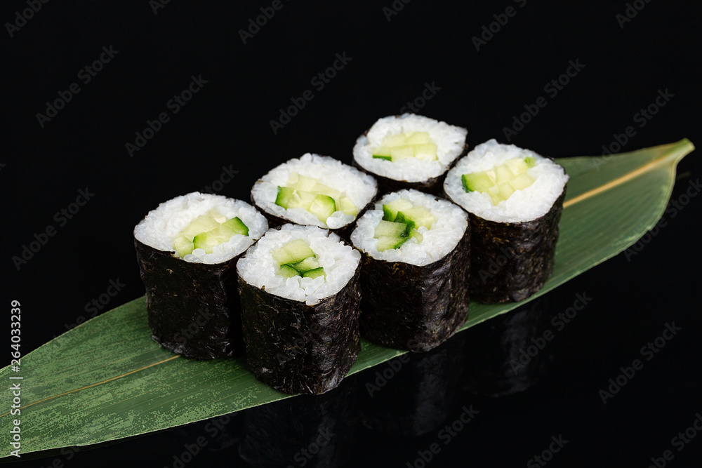 sushi rolls with cucumber on black background sushi rolls with cucumber on black background