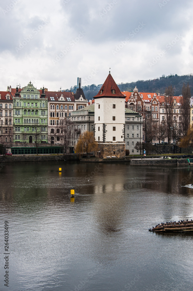Fototapeta premium Old white tower on the border of the river