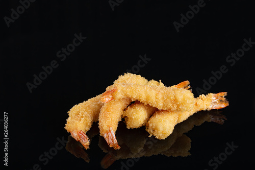 Fried Shrimps tempura in black plate on dark concrete surface background. Seafood tempura dish