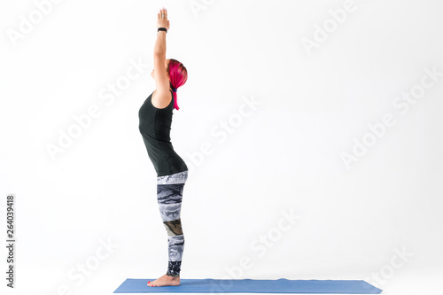 Girl standing in tadasana pose doing yoga on white background photo