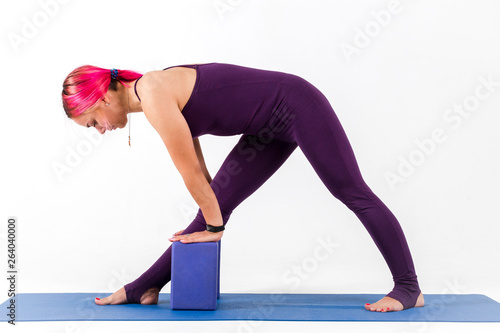 Girl standing in parsvottanasana pose doing yoga on white background photo