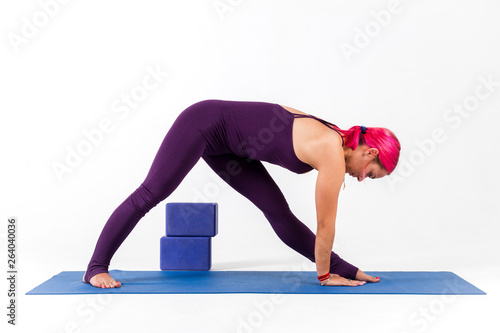 Girl standing in parsvottanasana pose doing yoga on white background photo