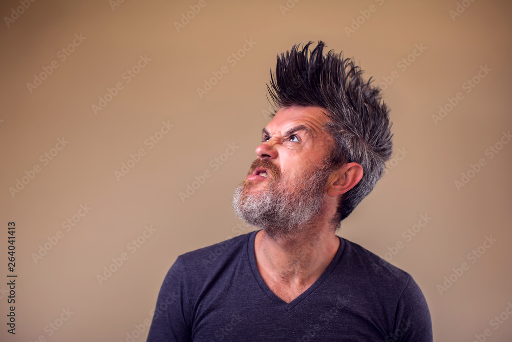 Closeup portrait of an angry adult man with a beard and iroquois Closeup portrait of an angry adult man with a beard and iroquois