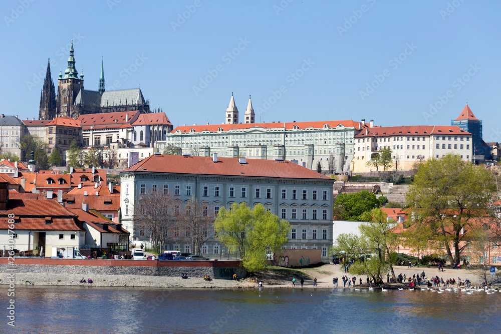Obraz premium Spring green Prague Lesser Town with gothic Castle above River Vltava in the sunny Day, Czech Republic